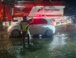 TNI Sigap Di Tengah Banjir: Babinsa Koramil 1405/05 Mallusetasi Turun Ke Jalan Atur Lalu Lintas Di Tengah Banjir Poros Trans Sulawesi